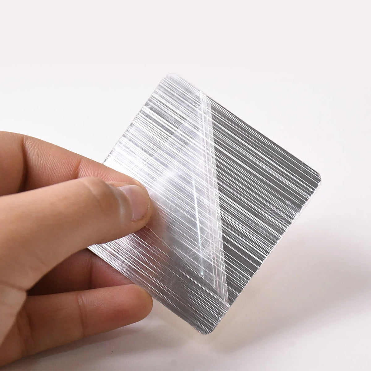 Peel off the backing film of the adhesive hook